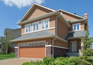 A brown house with green trees on the lawn